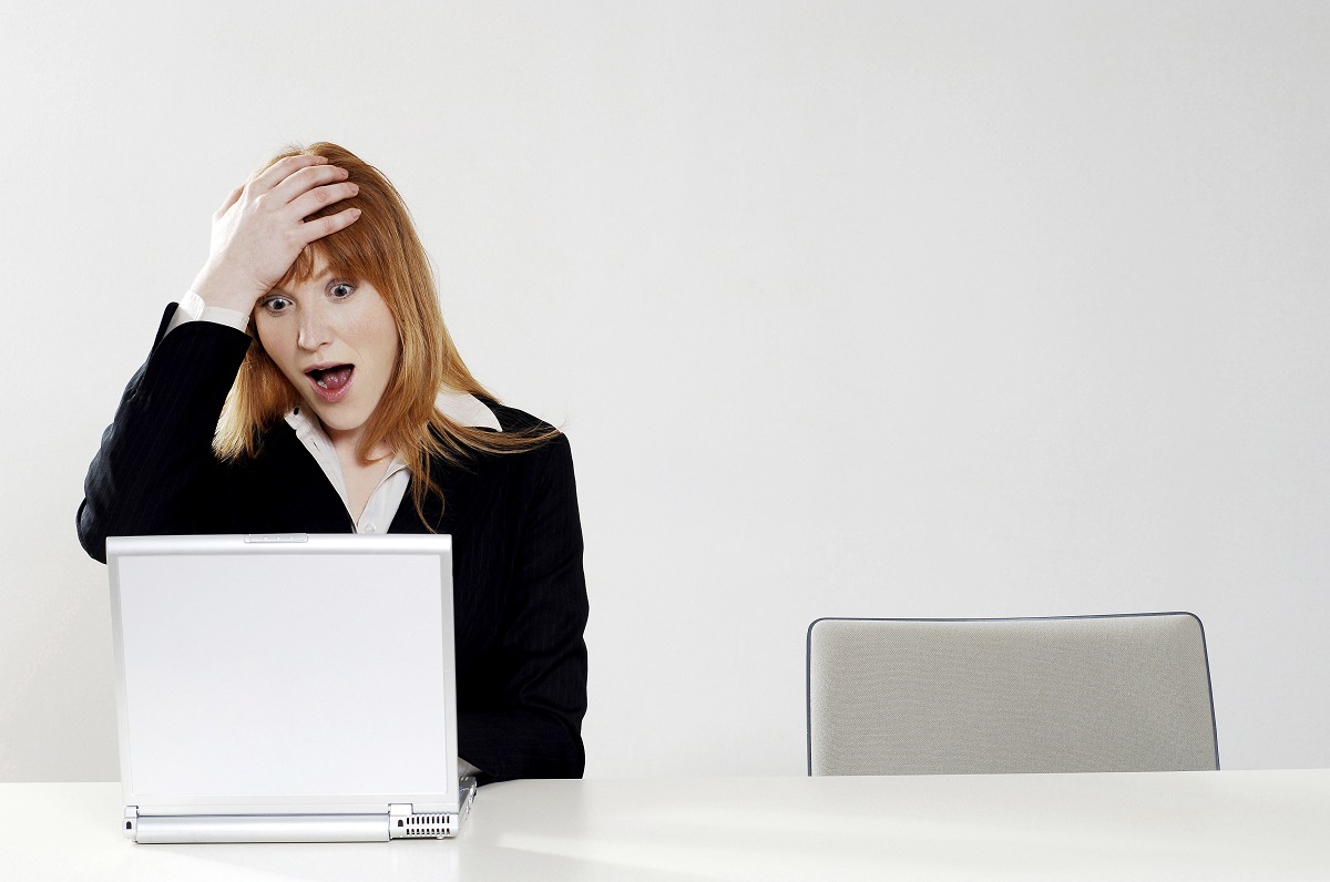 woman shocked looking at laptop